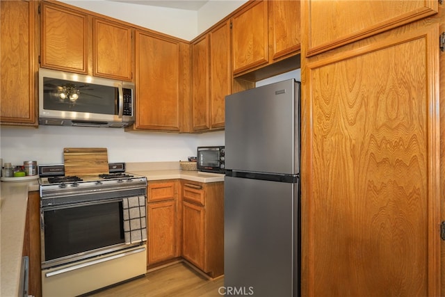 kitchen with stainless steel appliances and light hardwood / wood-style floors