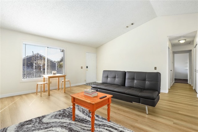 living room with wood-type flooring, vaulted ceiling, and a textured ceiling