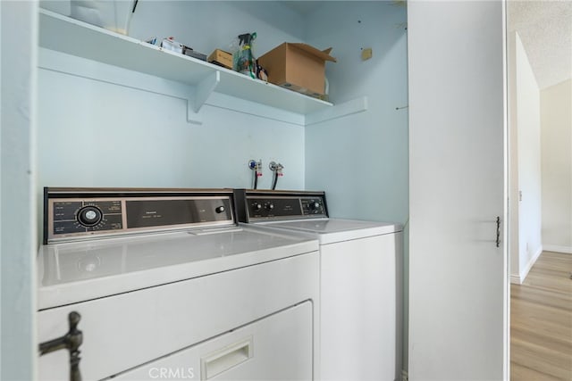 laundry room featuring washer and clothes dryer and light hardwood / wood-style floors