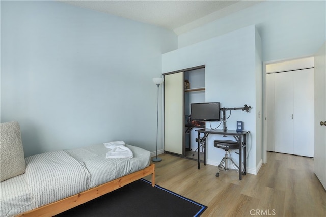 bedroom with light hardwood / wood-style flooring and a textured ceiling