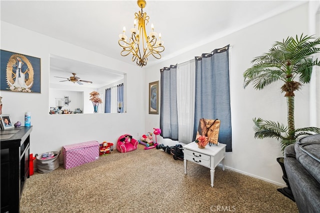 rec room featuring ceiling fan with notable chandelier, carpet floors, and baseboards