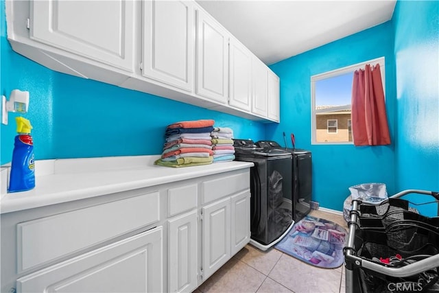 laundry area featuring washer and dryer, cabinet space, and light tile patterned flooring