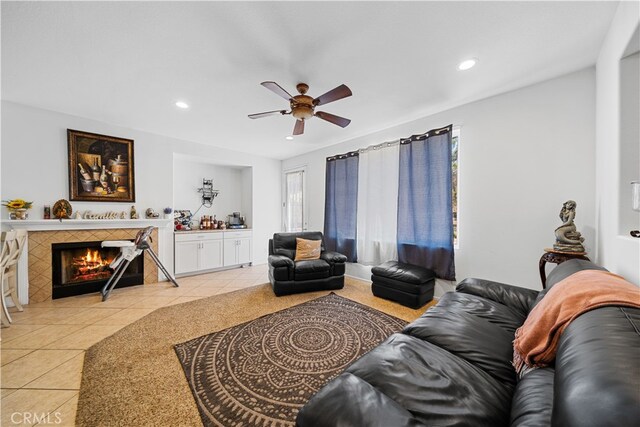 living room featuring ceiling fan, light tile patterned flooring, a fireplace, and recessed lighting