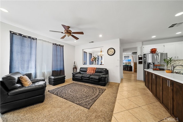 living area with ceiling fan with notable chandelier, recessed lighting, visible vents, and light tile patterned floors