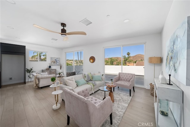 living room with ceiling fan and light hardwood / wood-style floors