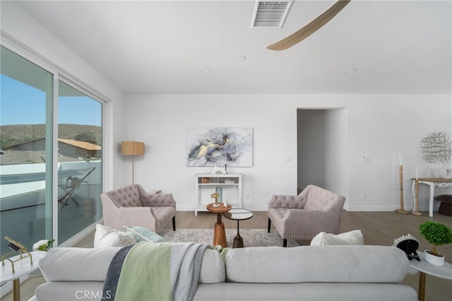 living room featuring ceiling fan and wood-type flooring