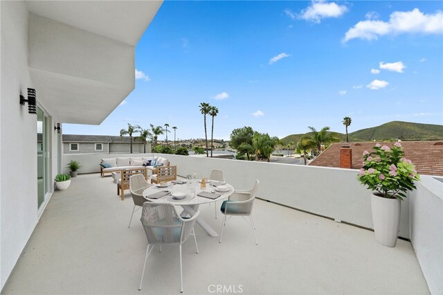 view of patio featuring a mountain view, a balcony, and an outdoor hangout area