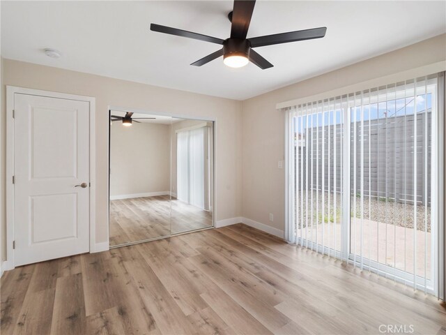 spare room featuring light hardwood / wood-style floors, ceiling fan, and a healthy amount of sunlight