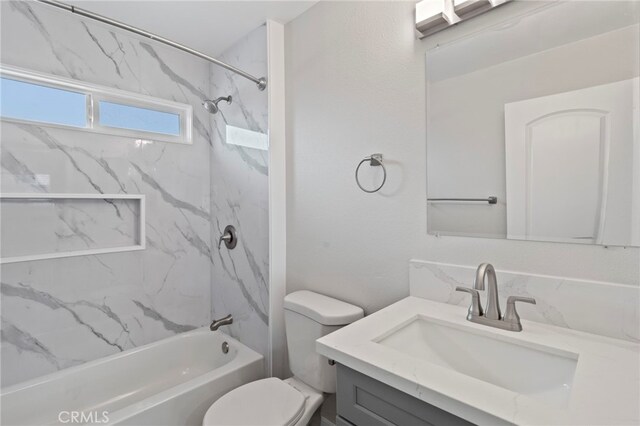 full bathroom with tiled shower / bath combo, vanity, and toilet