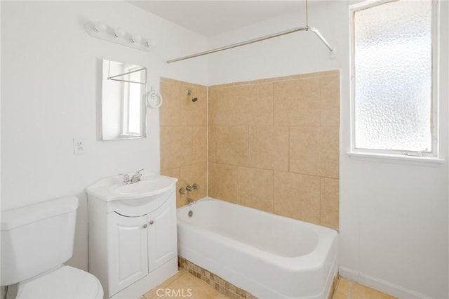 full bathroom with tile patterned floors, vanity, tiled shower / bath combo, and toilet