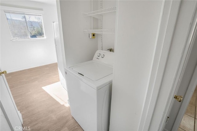 laundry area with light hardwood / wood-style flooring and washer / dryer