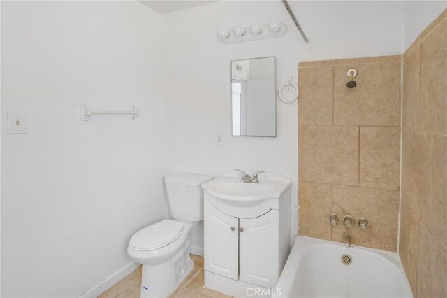 bathroom with tile patterned flooring, vanity, a tub to relax in, and toilet