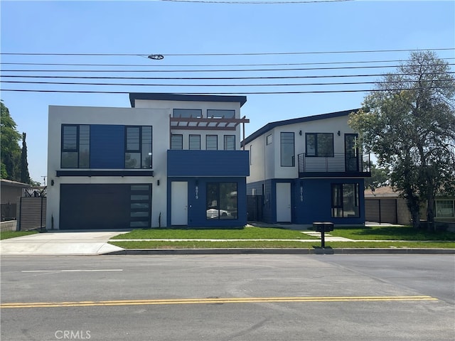 contemporary house featuring a balcony, a garage, and a front lawn