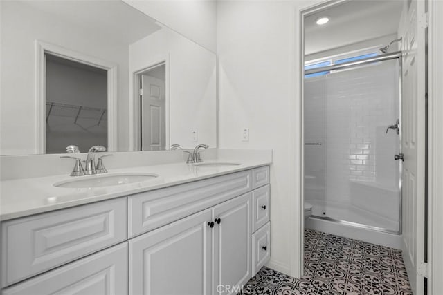 bathroom featuring vanity, toilet, tile patterned flooring, and walk in shower