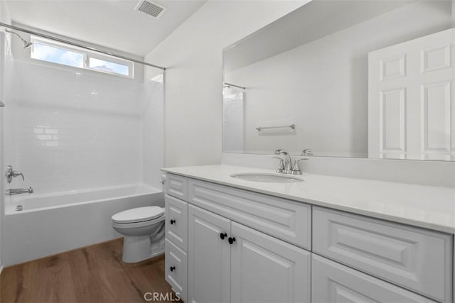 full bathroom featuring hardwood / wood-style floors, washtub / shower combination, vanity, and toilet