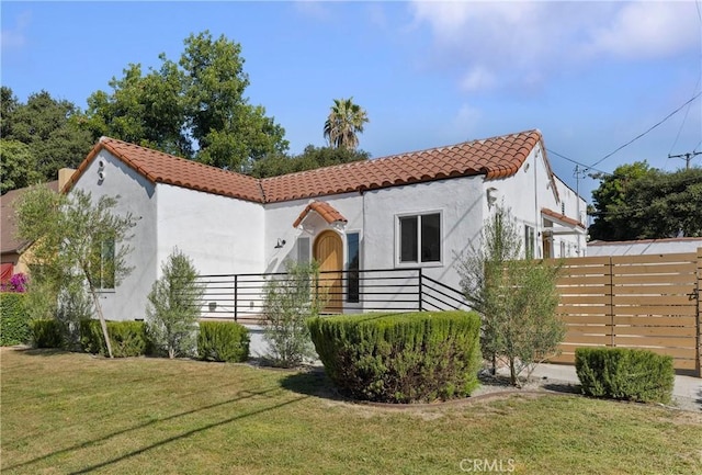 mediterranean / spanish home featuring a front lawn