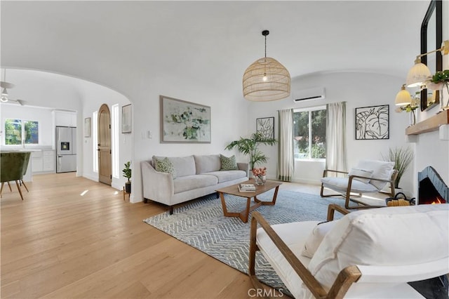 living room featuring light hardwood / wood-style floors and a wall unit AC