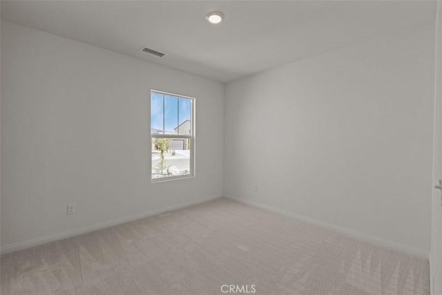 spare room featuring light colored carpet