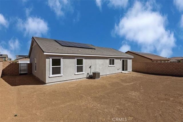 rear view of house with solar panels and central air condition unit