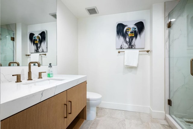 bathroom featuring a shower with door, vanity, and toilet