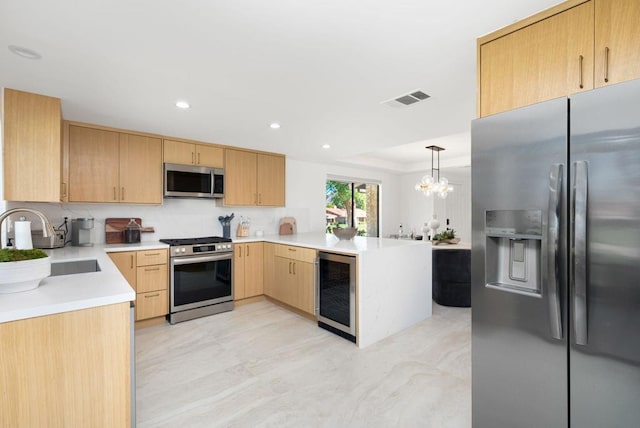 kitchen with stainless steel appliances, wine cooler, pendant lighting, an inviting chandelier, and light brown cabinetry