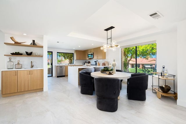 dining area with a chandelier, a tray ceiling, and plenty of natural light