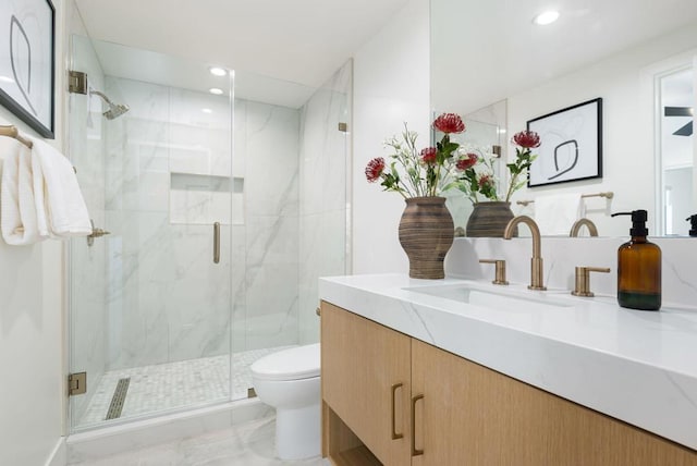 bathroom with vanity, a shower with shower door, and toilet