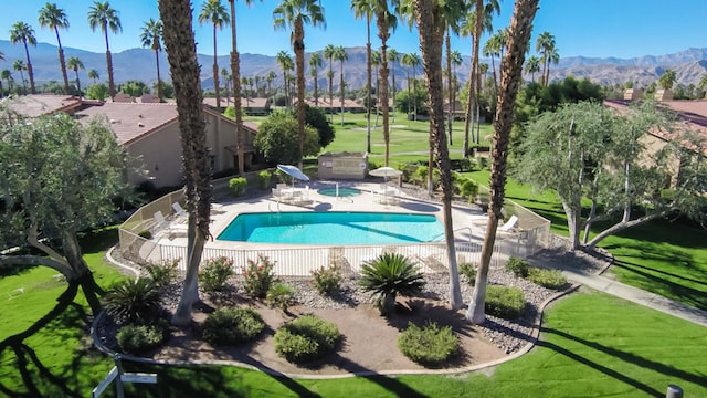 view of swimming pool featuring a yard, a mountain view, and a patio