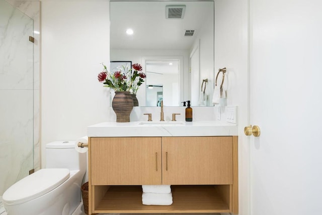 bathroom with vanity, toilet, and a shower with door