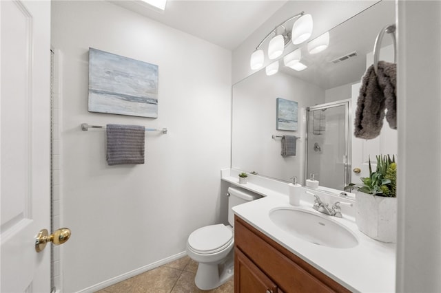 bathroom featuring tile patterned floors, vanity, a shower with shower door, and toilet