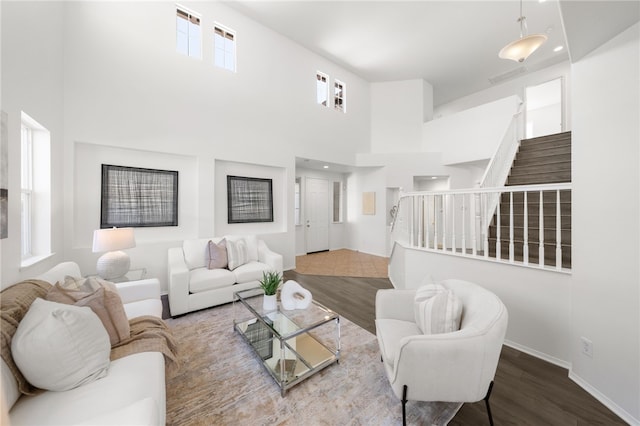 living room with wood-type flooring and a towering ceiling