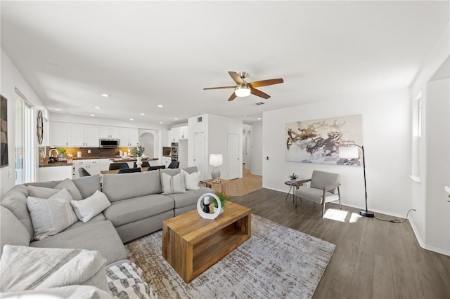 living room with ceiling fan and light wood-type flooring