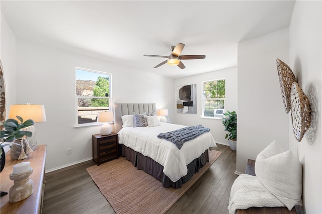 bedroom featuring dark hardwood / wood-style floors, multiple windows, and ceiling fan