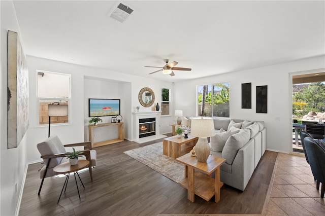 living room with ceiling fan and dark wood-type flooring