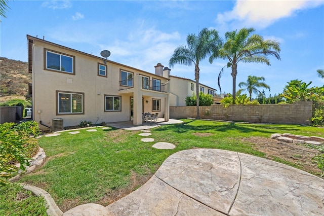 back of property featuring a yard, central AC, a balcony, and a patio