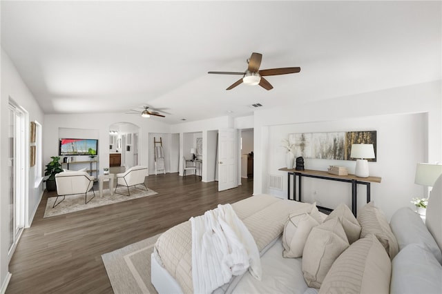 living room featuring dark hardwood / wood-style floors, vaulted ceiling, and ceiling fan