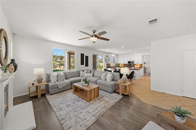 living room featuring ceiling fan and hardwood / wood-style flooring