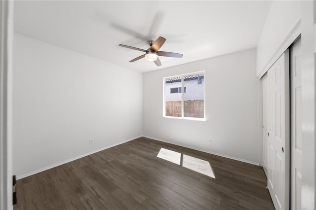 unfurnished bedroom with a closet, dark hardwood / wood-style floors, and ceiling fan