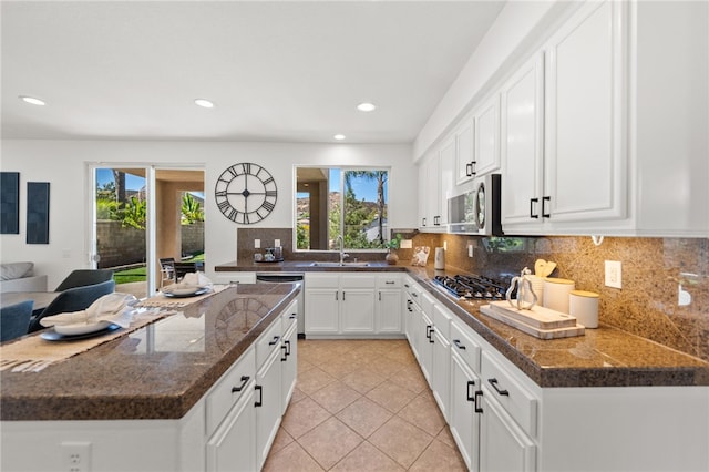 kitchen with stainless steel appliances, white cabinetry, plenty of natural light, and sink