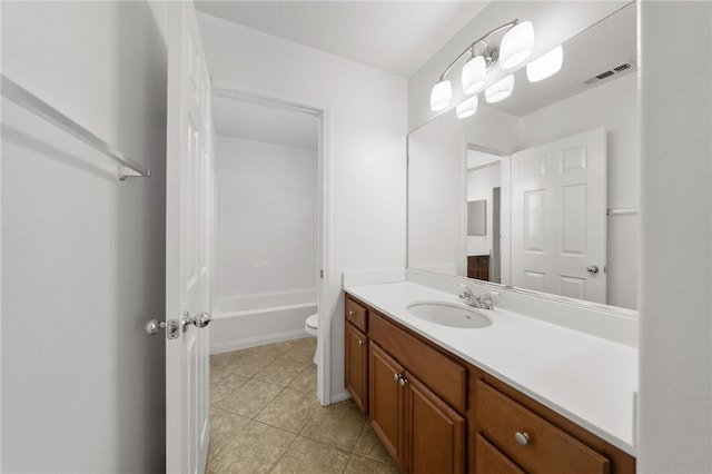 bathroom with toilet, vanity, and tile patterned floors