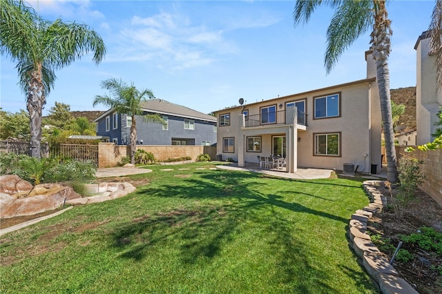 rear view of property with central AC unit, a patio area, a balcony, and a yard