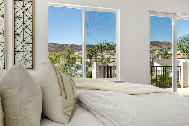 bedroom with a mountain view and access to exterior