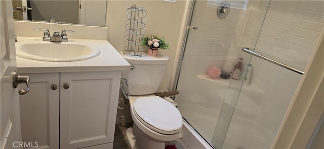 bathroom with vanity, a shower with shower door, and toilet