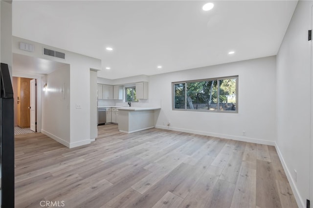 unfurnished living room featuring light hardwood / wood-style floors and sink