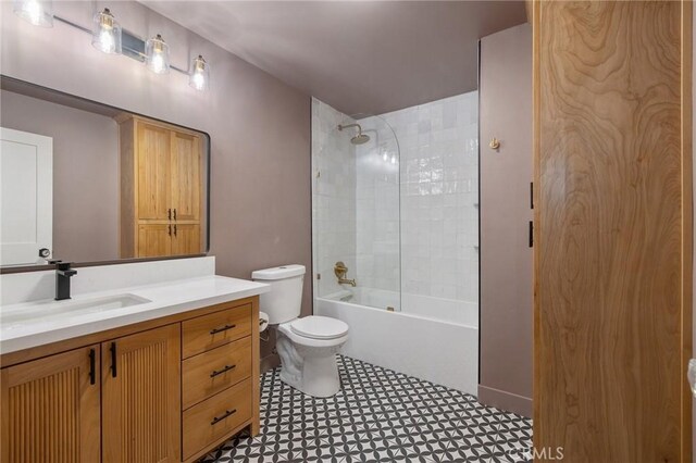 full bathroom featuring vanity, tile patterned floors, tiled shower / bath, and toilet