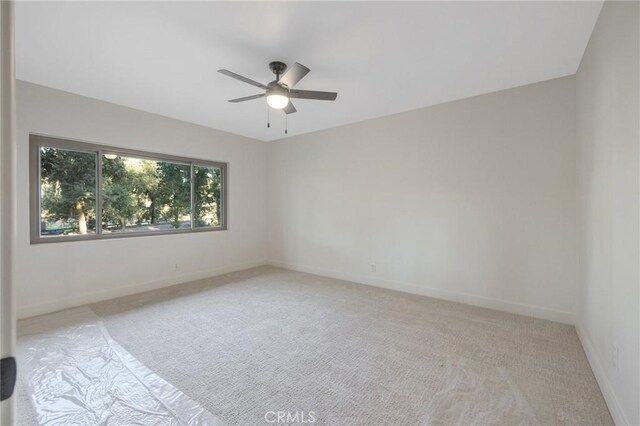 unfurnished room featuring ceiling fan and light colored carpet