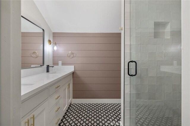 bathroom with vanity, lofted ceiling, wooden walls, and an enclosed shower