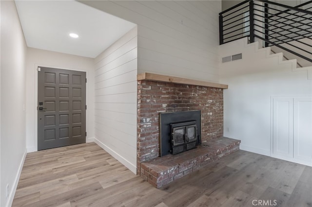 interior space with light hardwood / wood-style floors, a fireplace, and a high ceiling