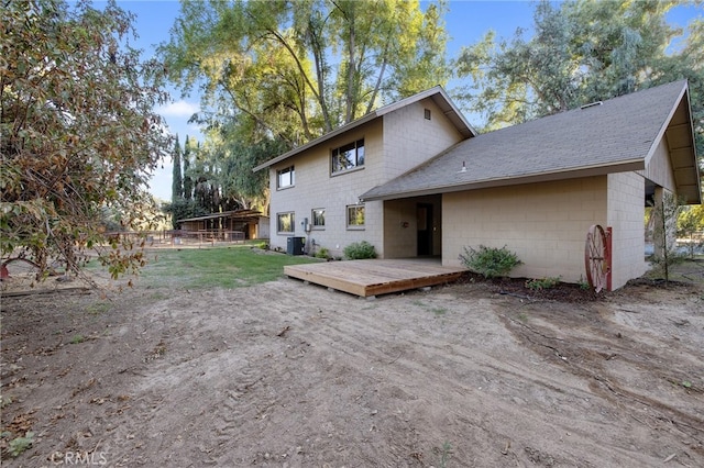 rear view of house featuring central AC unit and a wooden deck