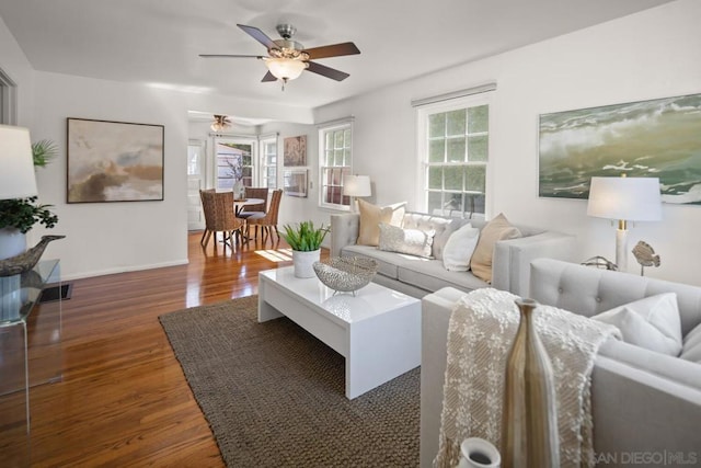 living room featuring ceiling fan and dark wood-type flooring